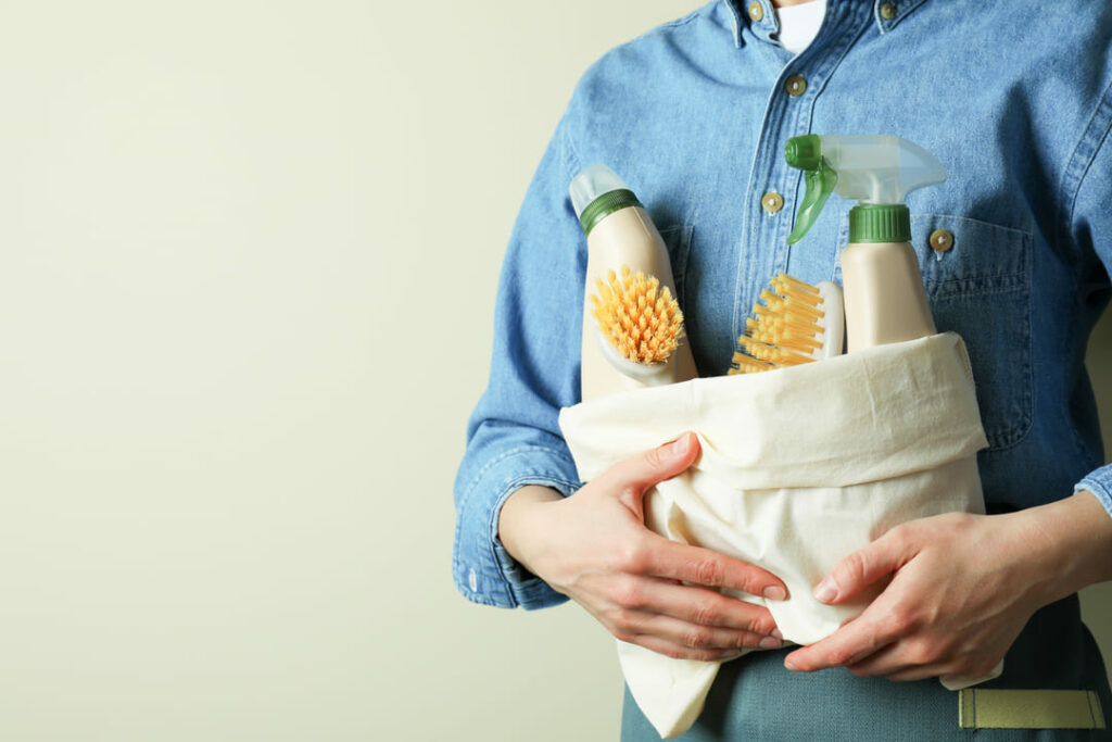 femme qui tient un sac de produits de nettoyages écologiques